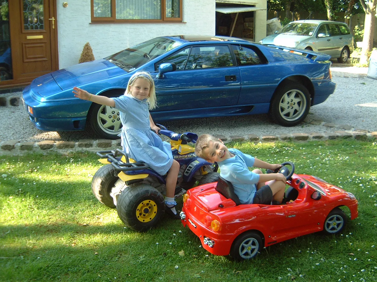 Hollie and Jordan beside Bibster's blue Lotus Esprit Turbo SE registration H15 LTS